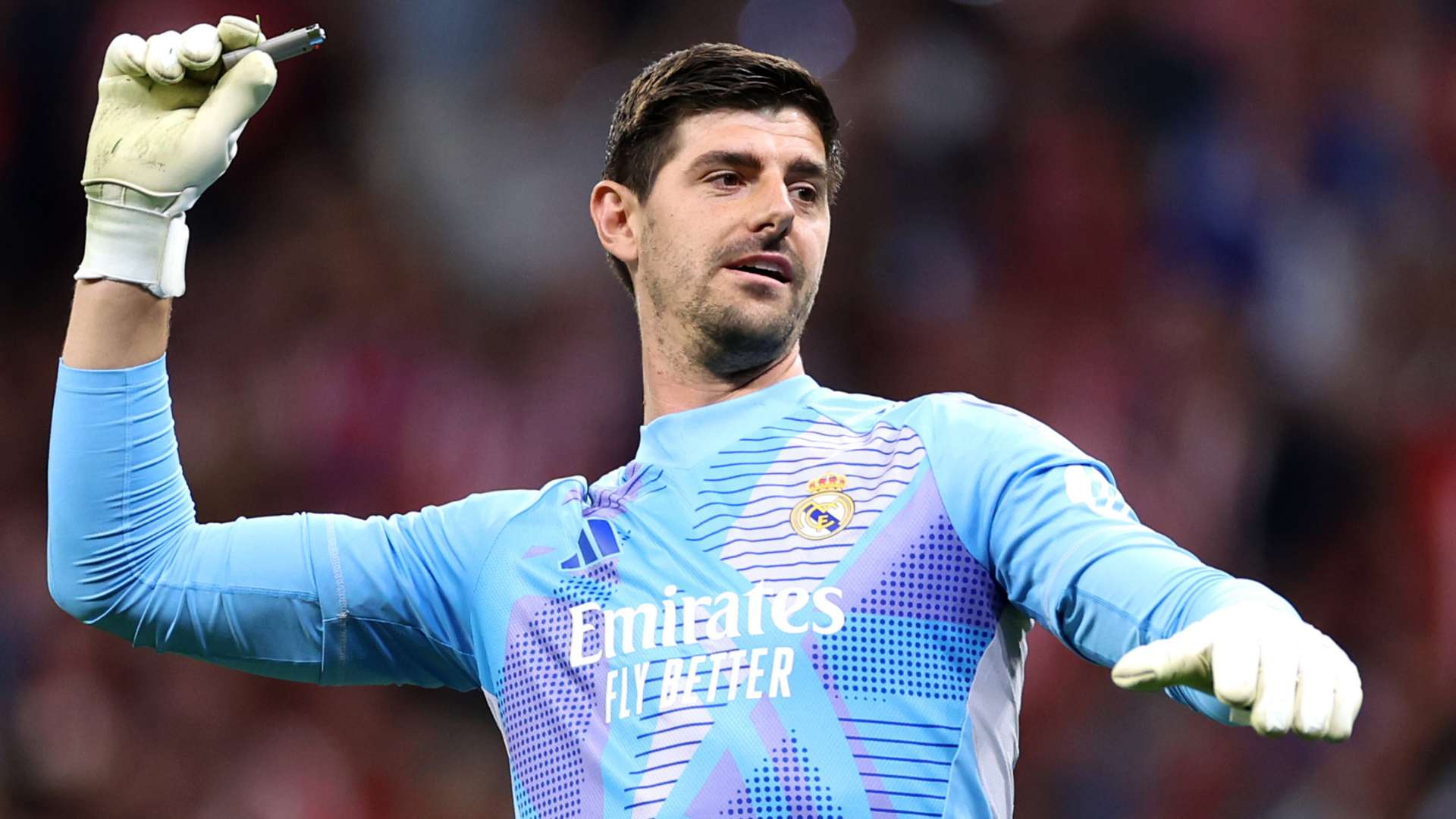 Real Madrid goalkeeper Thibaut Courtois throws a lighter during La Liga derby with Atletico